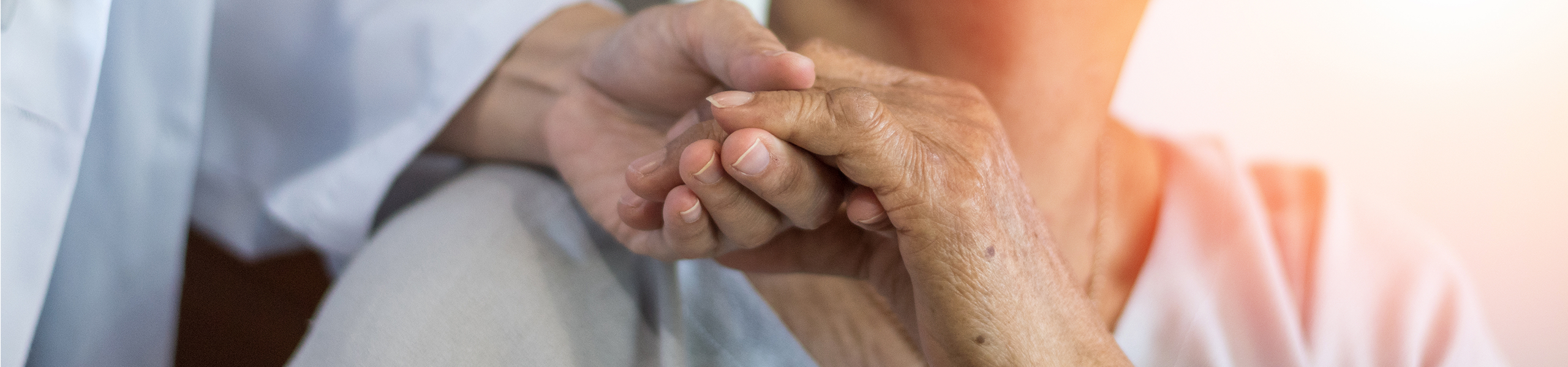 Senior holding caregivers hand on shoulder